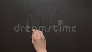 你好！ 一只左雌手写字`你好！用绿色粉笔在黑板上`。 你好写在黑板上